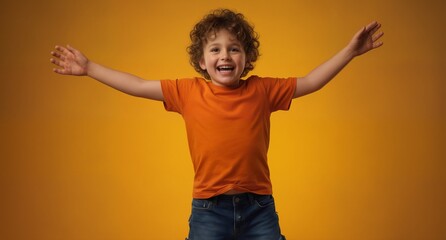 joyful young boy with curly hair embracing happiness in a vibrant orange t-shirt against a warm yellow background.