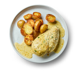 plate of fried boiled potatoes and chicken breast with creamy curry sauce