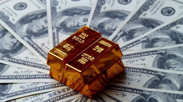 Close Up Of A Shining Gold Bar Placed On Scattered US One Hundred Dollar Bills. Concept Of Wealth Investment Financial Security And Gold And Currency Reserves. close-up