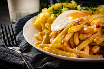 Fried eggs with boiled potatoes and yellow string beans.
