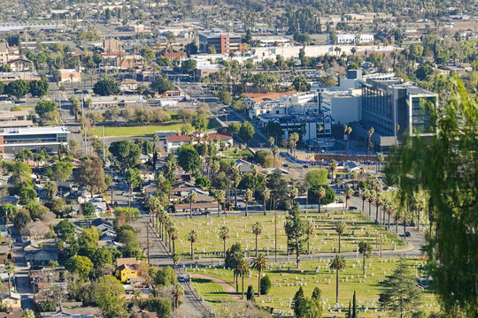 Elevated view from Mount Rubidoux overlooking Riverside, California, with Evergreen Cemetery, palm trees, neighborhoods, and city buildings below.