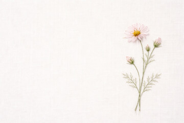 Delicate embroidered flower twig on white fabric. Space for text.
