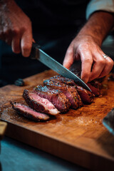 ribeye steak thinly sliced by chef, medium rare ribeye beef being carved, gourmet cooked ribeye in kitchen