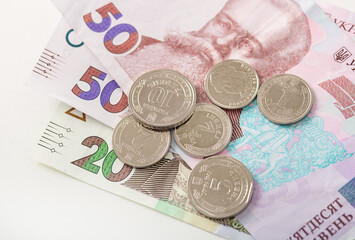 Close-up of Ukrainian hryvnia coins (1, 2, 5, 10 denominations) on 20 and 50 hryvnia banknotes, national currency of Ukraine.