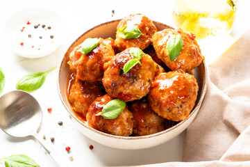 Glazed Meatballs in tomato sauce on white table.