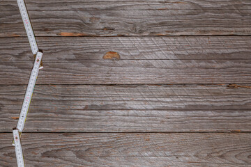 Folding Measuring Stick Along Left Edge on Weathered Wood
