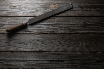 Worn Metal File on Dark Weathered Wood Background Top View
