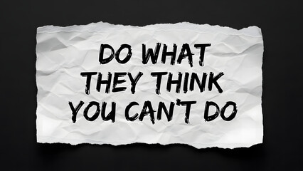 Crumpled paper with motivational quote on dark background .