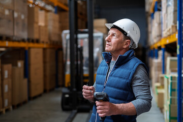 Portrait of mature warehouse worker with helmet.