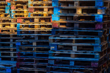 Colorful Stacked Wooden Pallets in an Industrial Yard Creating Vibrant Urban Warehouse Atmosphere and Texture
