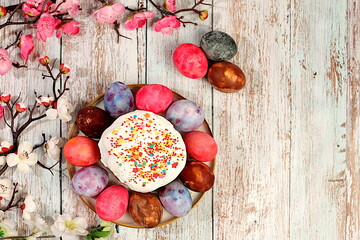 Traditional kulich and marbled Easter eggs painted with onion peel, hibiscus tea and pink matcha with sakura branches, Easter celebration concept, Easter dish ideas for home cooking