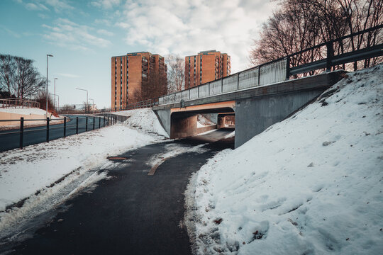 A wide shot showing a pedestrian tunnel beneath a road bridge, with the characteristic Elineberg brick towers in the background.