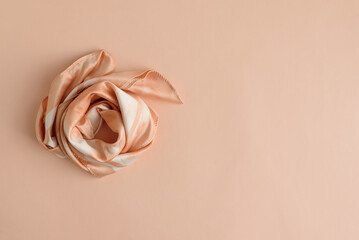 Silk Scarf Styled as Rose on Peach Background. Festive Spring Flatlay