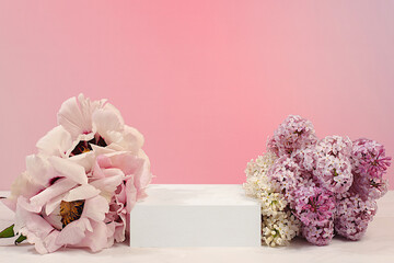 Empty podium with spring lilac flowers and mountain peony.Abstract floral arrangement with lilac flowers, banner. Creative template for your design.Minimal modern aesthetics, elegant beauty concept