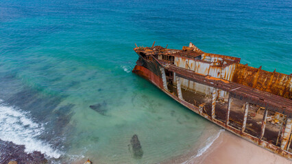 Aerial View of Rusty Shipwreck on Turquoise Beach