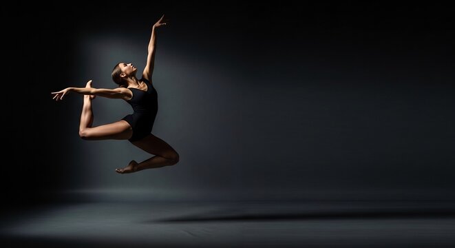 Graceful Dancer in Mid-Air - A Stunning Silhouette Against a Dark Backdrop.