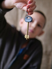 Child Holding a Large Brass House Key - Boy Presenting a Key for a New Home or Property