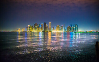 Beautiful night view of Doha city, skyscrapers of financial area and reflection in bay water. Qatar	