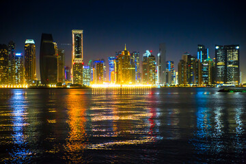 Beautiful night view of Doha city, skyscrapers of financial area and reflection in bay water. Qatar	