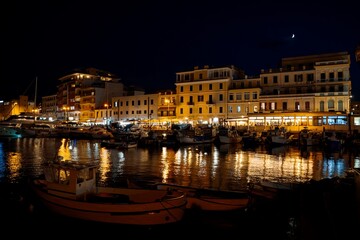 Fototapeta premium Night Marina with Boats and Illuminated Waterfront