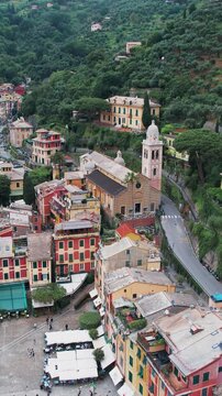 Aerial view of charming village of Portofino, Italy, with its colorful houses, a historical church Chiesa Divo Martino, vertical video