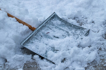 A gray snow shovel lying in the sno © Koppes Visuals