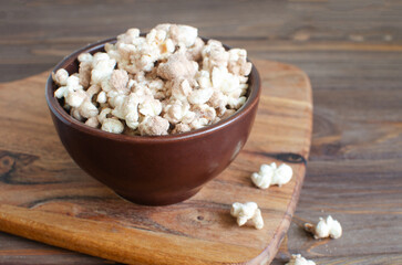 Protein popcorn in a bowl on a wooden background