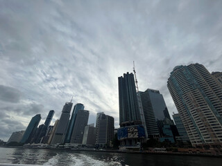 Obraz premium Modern city skyline with towering skyscrapers and dramatic cloudy sky above