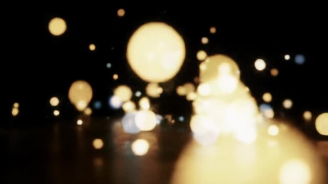 Mesmerizing, abstract video of luminous, shimmering bokeh lights in soft golds, ambers, blues, drifting gracefully across a velvety black void with shallow depth of field. Dreamlike ambiance