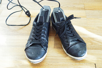 Electric foot hygiene device powered on showing an active bacterial elimination cycle for urban footwear. Illustrates thermal decontamination technology and removal of invisible microbial threats.