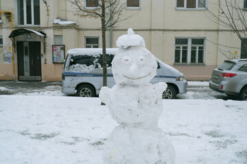 Snowman in Urban Setting with Building in Background