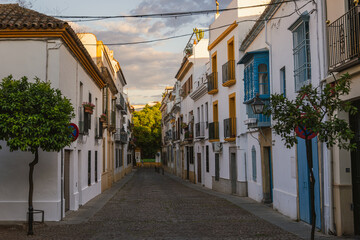 Fototapeta premium Picturesque Spanish street with white walls, Cordoba, UNESCO World Heritage site. Narrow whitewashed street in the historic Jewish Quarter of Cordoba, Andalusia (Andalucia), Spain.