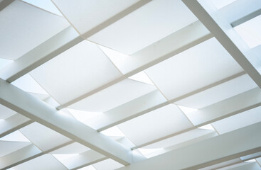 White modern tensile shade structure creating a geometric abstract pattern, forming a contemporary architectural ceiling or background with clean lines and soft diffused light