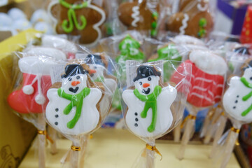 Festive holiday-themed lollipops wrapped and displayed, featuring a cheerful snowman design. The...