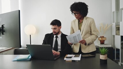African American female business woman working at finance company, reviewing financial documents with business colleague  - Powered by Adobe