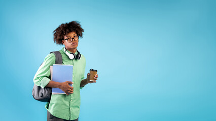 So tired. African american guy with notebooks, backpack and takeaway coffee, feeling fatigue from...