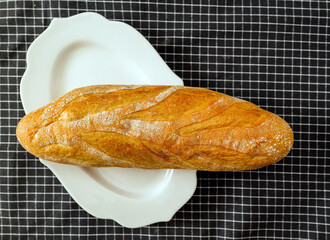 Freshly baked bread on a white plate in a kitchen
