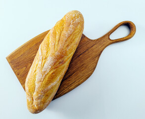 Fresh bread on a wooden board in a kitchen