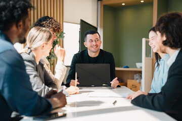 Fototapeta premium Professional business team having meeting discussing corporate strategy and project results using laptop in modern city environment showing teamwork leadership confident collaboration spirit