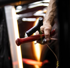 Process of paintless dent repair on car body. The mechanic at the auto shop with tools to repair dents in car body. Body repair. A specialist repairs a dent on the car body without painting. PDR. 