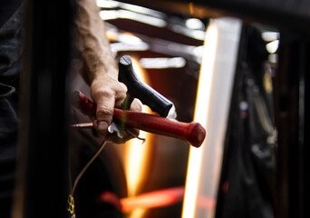 Process of paintless dent repair on car body. The mechanic at the auto shop with tools to repair dents in car body. Body repair. A specialist repairs a dent on the car body without painting. PDR. 