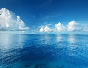 tranquil blue ocean under clear sky with soft white clouds reflecting in calm water for serene nature and travel background or wallpaper use