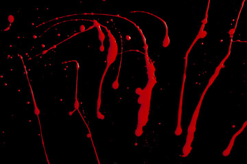 drops and splashes of red paint on a black background