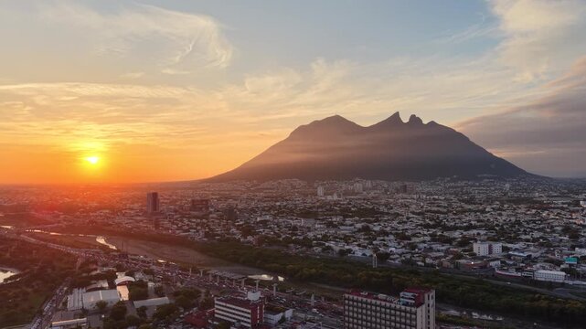 Drone aerial sunrise over Monterrey skyline with Cerro de la Silla, Mexico