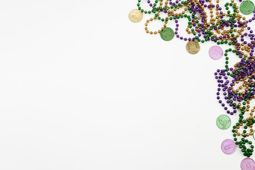 Mardi gras beads and doubloons on white background