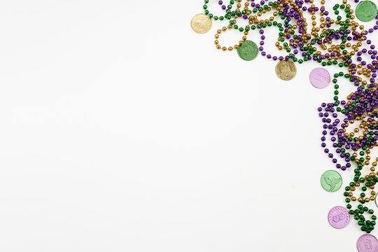 Mardi gras beads and doubloons on white background