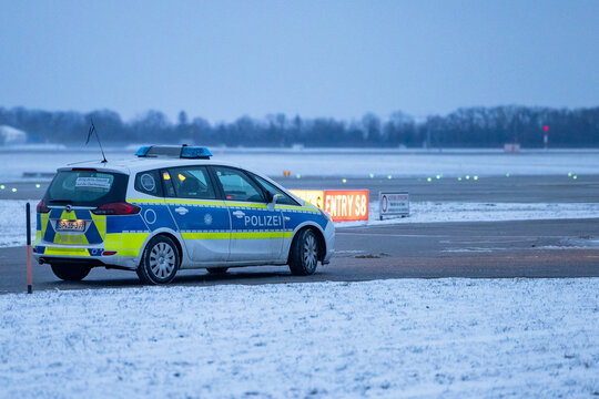 Ein Fahrzeug der Bundespolizei &uuml;berwacht bei Schnee das Vorfeld des Flughafens M&uuml;nchen. 