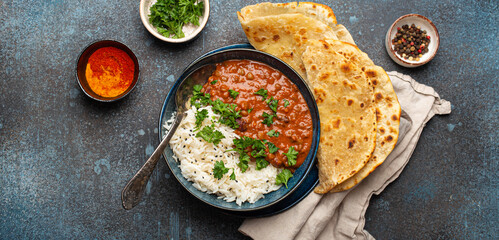 Traditional Indian Punjabi dish Dal makhani with lentils and beans in black bowl served with basmati