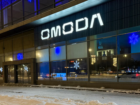 Facade of Omoda car store at night LED backlight. Omoda is an automobile manufacturer. Chinese Motor Corporation. Omoda Cars in the showroom with LED backlight. 