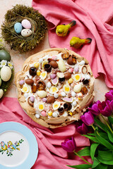 Easter chocolate pavlova decorated with different chocolate eggs on Easter background